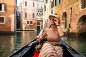 Woman on a gondola tour in Venice, Italy
