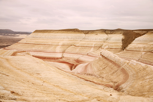 Unique geological feature known as tiger-striped mountains, showcasing layers of sedimentary rock in warm tones that resemble the stripes of a tiger.