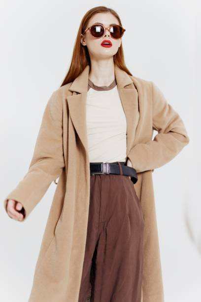 istock Strict professional model red-haired young woman posing in glasses coat on a white background in the studio. Catalog photography 2148238637