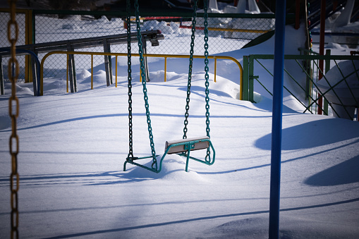 Chain swing is covered with snow