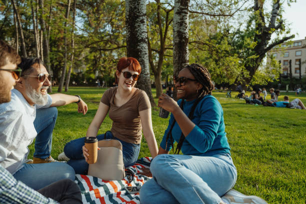 istock Group of diverse friends outdoors on picnic talking and drinking coffee to go 2148239900