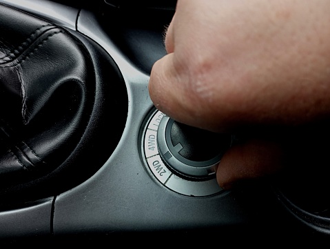 A human hand switches the off-road mode of the car with a switch. Connecting the distribution of the second rear axle of the car.