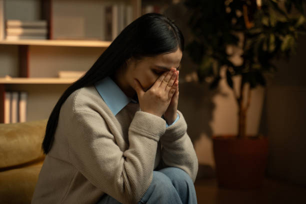 istock Young Asian Woman Experiencing Intense Headache at Home During Evening 2148240710