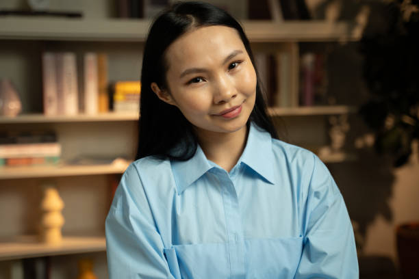 istock Young Asian Woman Smiling and Conversing During a Casual Indoor Interview 2148241123