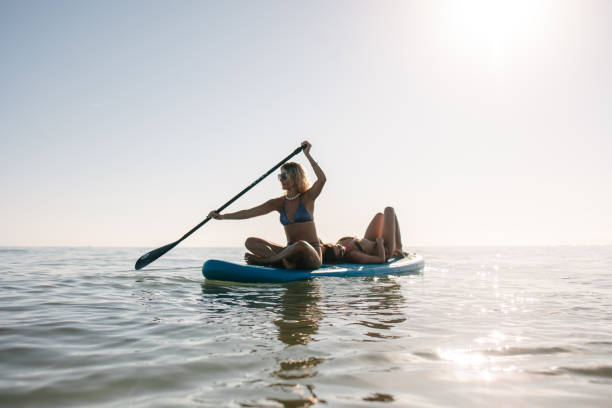 istock Female friends on stand up paddling board 2148241403