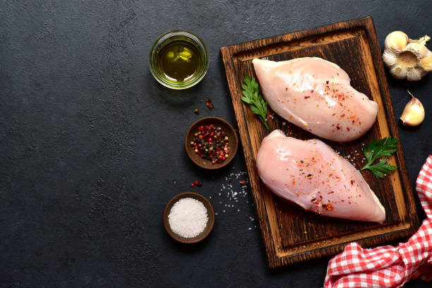 istock Raw chicken fillet or breasts with ingredients for cooking. Top view with copy space. 2148242448