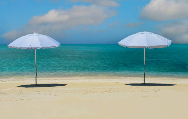 Turquoise Beach with parasol sunshade and sailboat yachts, Turks and Caicos islands, Caribbean sea