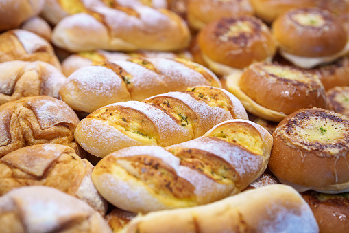 A bakery shop displays various freshly baked bread buns, showcasing a range of options for customers.
