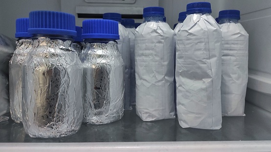 bottle wrapped by aluminium voil and white paper in refrigerator