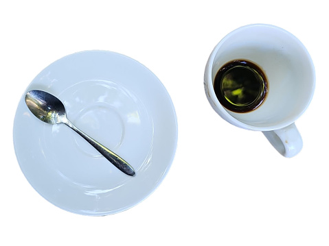 A white plate with spoon placed on top. and a white coffee mug with espresso in it Isolated on white background.