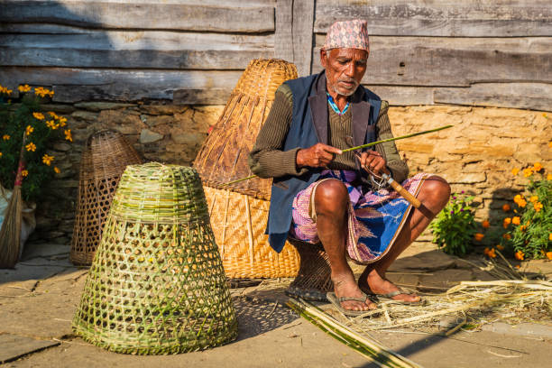 Nepali old man making a basket, village in Annapurna Conservation Area.. The Annapurna region is in western Nepal where some of the most popular treks (Annapurna Sanctuary Trek, Annapurna Circuit) are located. Peaks in the Annapurnas include 8,091m Annapurna I, Nilgiri and Machhapuchchhre. The Annapurna peaks are among the world's most dangerous mountains to climb.