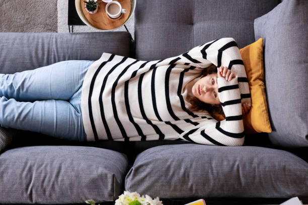 istock Top view depressed young woman lying on sofa 2148245196