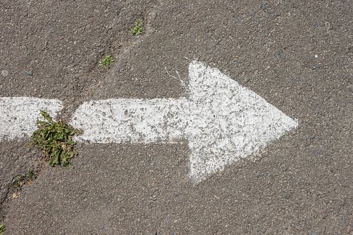 A white arrow is drawn on the asphalt