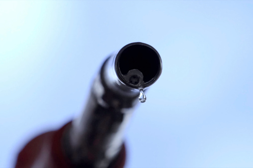 A drop of gasoline falls off the refueling gun. Filling station.