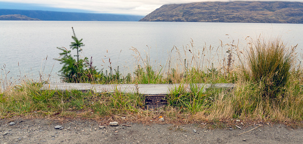 Queenstown, New Zealand- 3 April, 2024: In Queenstown, a plaque on a stone commemorates the 1990 Rifle Butts, erected due to the rumored threat of Russian invasion, now overlooking Lake Wakatipu.
