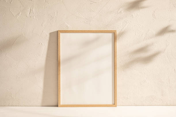 istock Blank Canvas in Wooden Frame Against Textured Wall in Soft Light With Shadows 2148251148