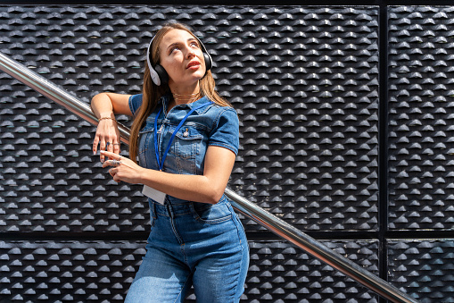 Young business woman with headphones on modern background