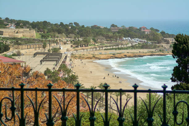 A golden sunset illuminates the beach of Tarragona, where the calm sea and soft sand invite you to relax and enjoy nature.