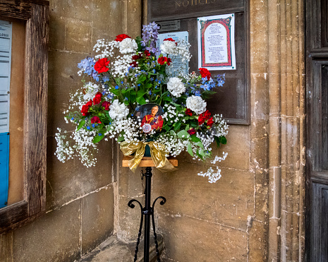 In a church porch stands a display of red, white and blue flowers to celebrate the coronation of King Charles III in 2023.