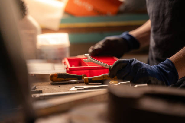Detail of repair shop owner choosing tool in workshop