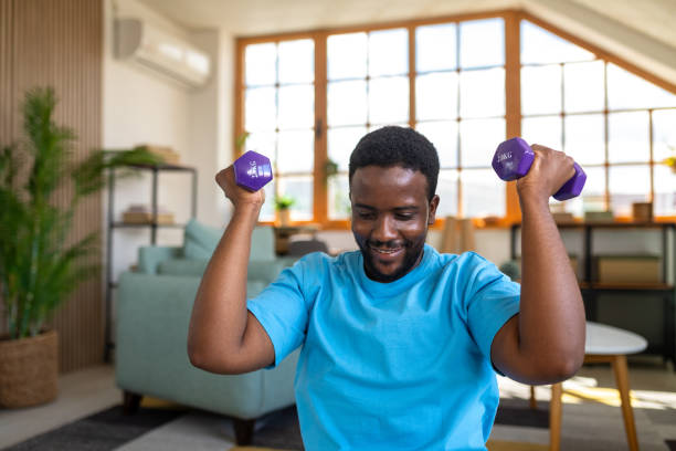 istock Young man using dumbbells to work out at home 2148255043