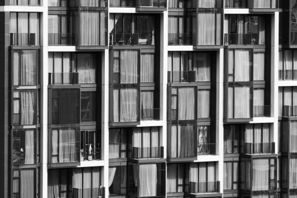 Window residential building apartment. Modern city skyscraper in day light. Apartment windows in modern skylines with day light with monochrome filter. Real estate. Closeup. Side view. Ornamented.