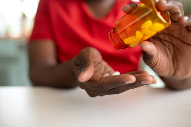 istock Young man taking medicine at home 2148255530