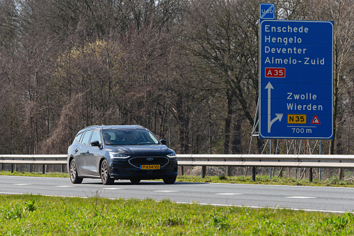 Netherlands, Overijssel, Twente, Wierden, March 19th 2023, side/front view close-up of a Dutch black 2022 hybrid Ford 4th generation Focus station wagon driving on the N36 at Wierden, the Focus is made by American car manufacturer Ford Motor Company since 1998, the N36 is a 36 kilometer long highway from Wierden to Ommen