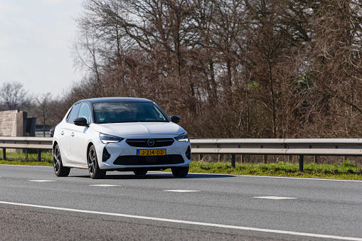 Netherlands, Overijssel, Twente, Wierden, March 19th 2023, side/front view close-up of a white 2020 Opel 6th generation Corsa 'F' hatchback driving on the N36 at Wierden, the Corsa is made by German manufacturer Opel Automobile GmbH since 1982, the N36 is a 36 kilometer long highway from Wierden to Ommen