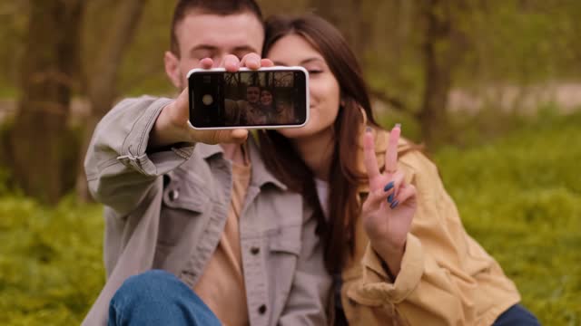 Young couple taking a selfie with a smartphone. Tourism services and travel, capturing the moment of travel, outdoor recreation, photo tours.