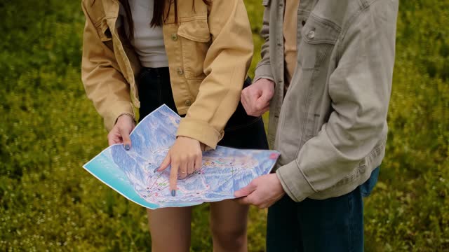 Travelers with a map in hand in forested terrain. Tours and tour operators, geolocation, and navigation apps for outdoor activities, promoting a healthy lifestyle