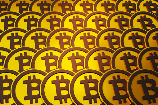 Golden bitcoins neatly arranged row by row fully filled the screen. Illustration of the concept of bitcoins, decentralized cryptocurrencies and blockchain