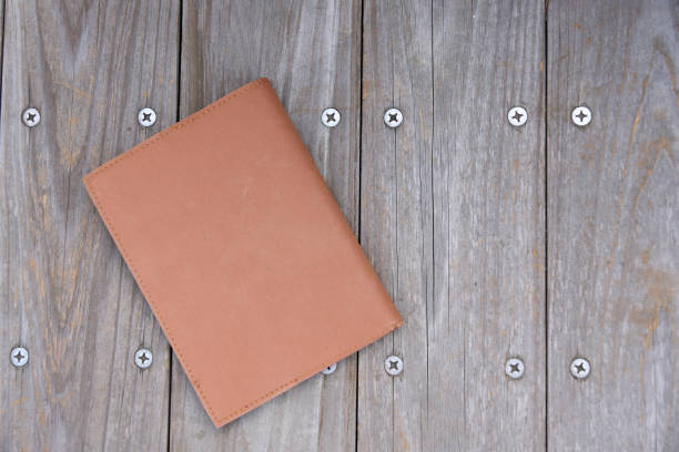 A book placed on a wooden bench outdoors.