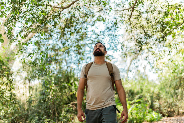 Mid adult man walking and looking around in the forest