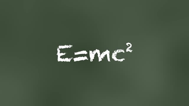 Famous E=mc2 equation animated. Relativity theory formula written with chalk on a board in a classroom.