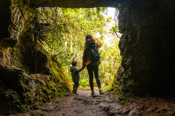 A woman and a child are standing in a cave
