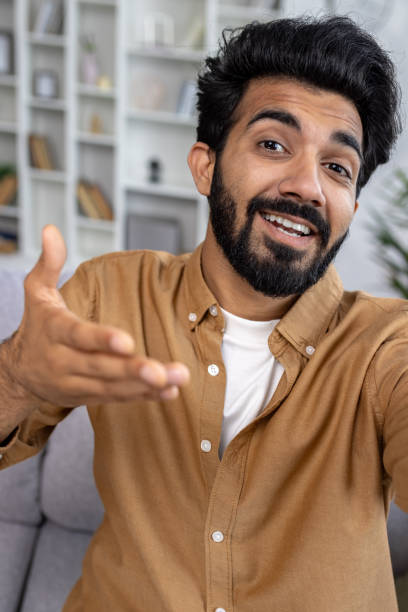 istock First person view of arab bearded man gesturing with hand while looking at camera during phone video call. Young casually styled male talking with friend while using wireless internet connection 2148266824