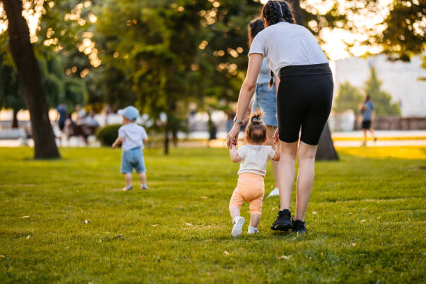istock Young Mother Teaching Her Daughter How To Walk In The Park 2148267413