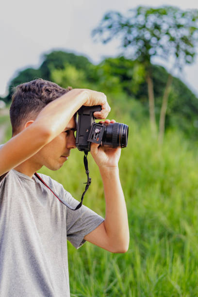 istock Freelance photographer taking photos, grass background. 2148267495