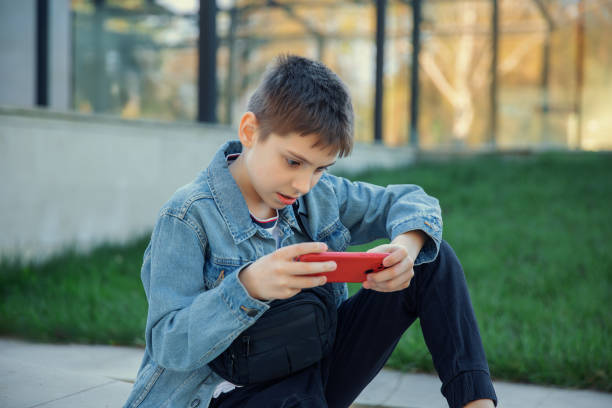 istock Boy engrossed in playing on the phone 2148267618