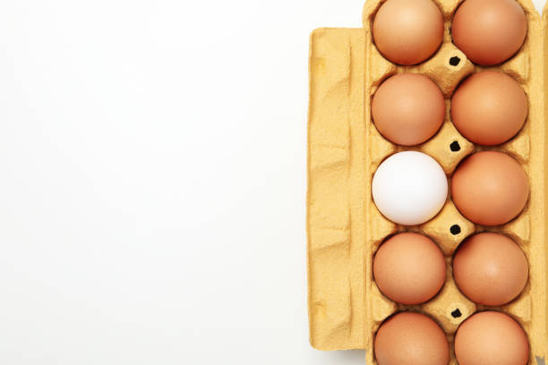 Overhead view of brown and white eggs in a cardboard carton