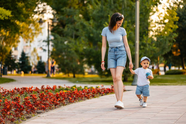 Beautiful young mother walking with her son in the park.