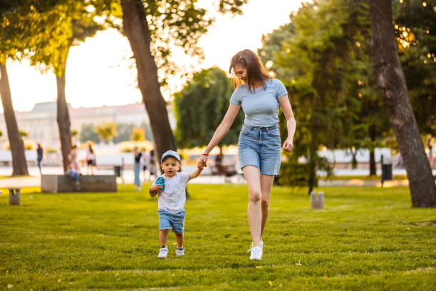 Young Mother Walking With Her Son In The Park