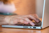 Human hand presses power button on laptop keyboard