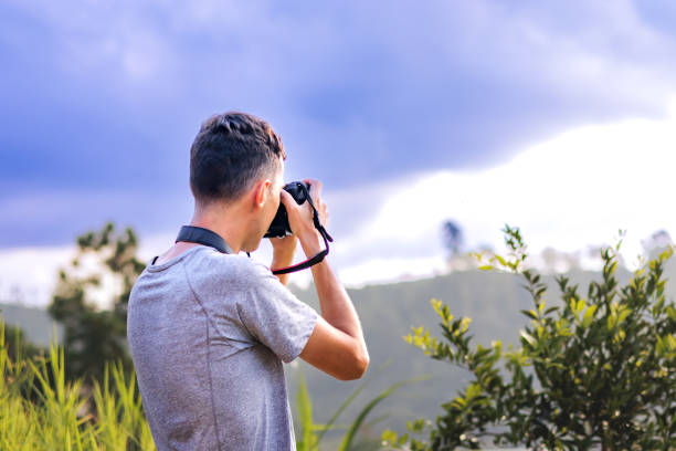 istock Photographer with camera on a mountain under a cloudy sky. 2148268382
