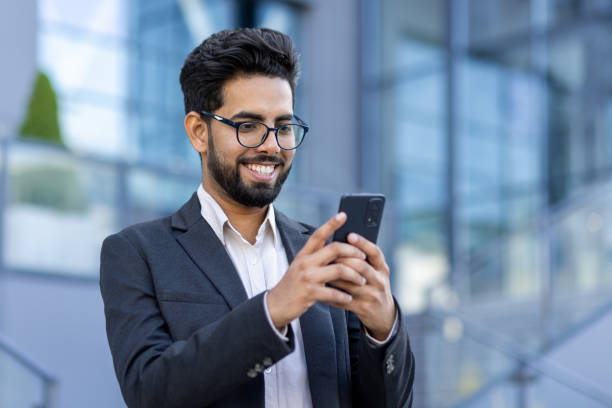 istock Professional Indian man using smartphone outside modern office building 2148268979