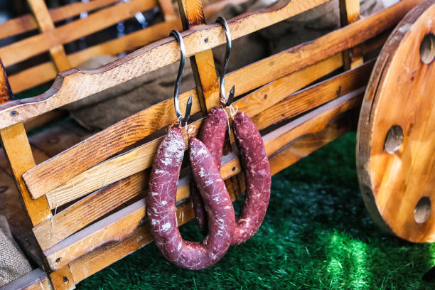 Two Sausages Hanging From a Wooden Wagon