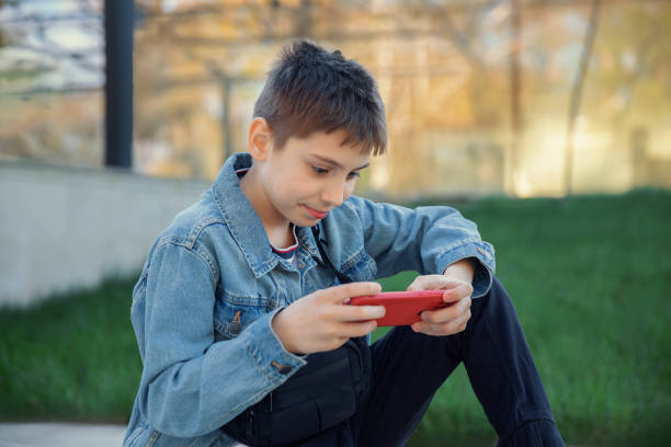istock Boy playing a game on the phone 2148269437