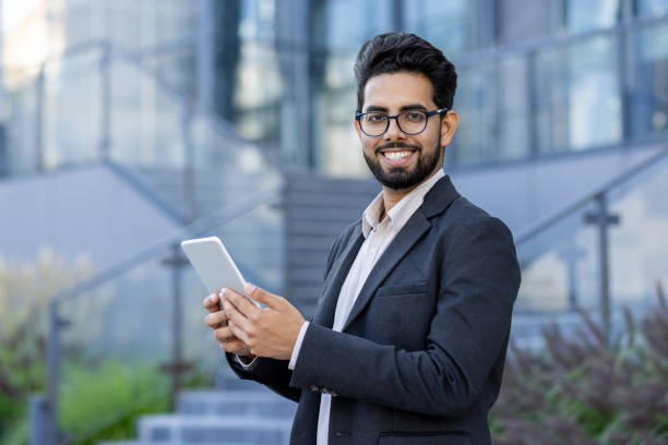 istock Professional Indian businessman using tablet with a smile outdoors 2148269595