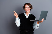Photo of cheerful lovely woman wear trendy black clothes presents novelty apple macbook isolated on grey color background